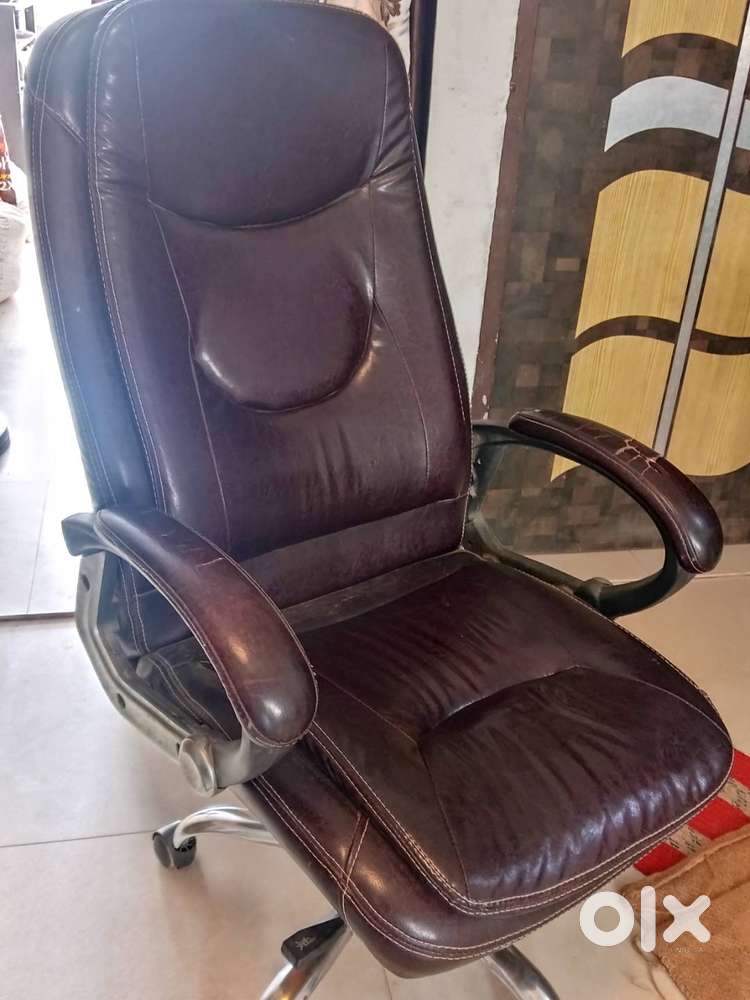 The image shows a brown leatherette high-back executive office chair,