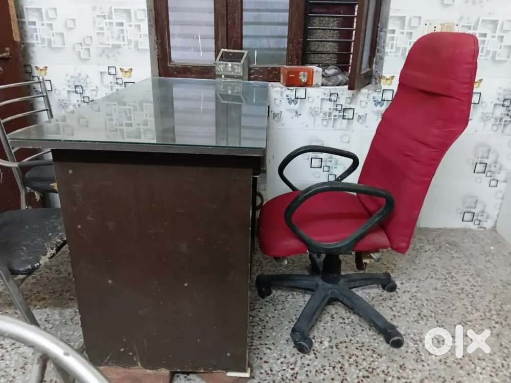A beautiful glass office table with red office chair
