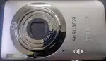 The image shows a Canon IXUS 115 HS digital camera. 