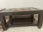 A centre wooden table without glass top is available for sale