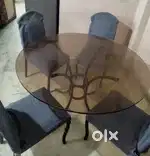 Dining table of toughened glass and with four chairs. godrej interio