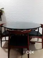 Round dining table with three chairs and one semi round bench