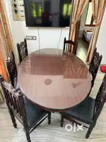 Oval shaped wooden dining table with glass top and 6 chairs