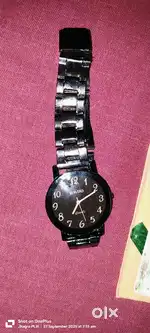 rado analog watch with a black dial and a stainless steel band