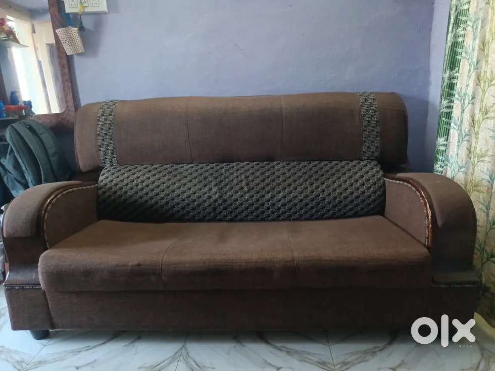 A wooden sofa with brownish colour with soft sponze