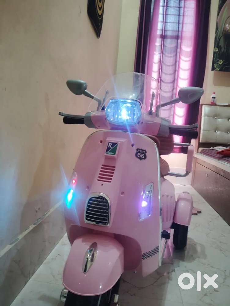 This is electric scooty by travelled by a four year girl with pinkcolo