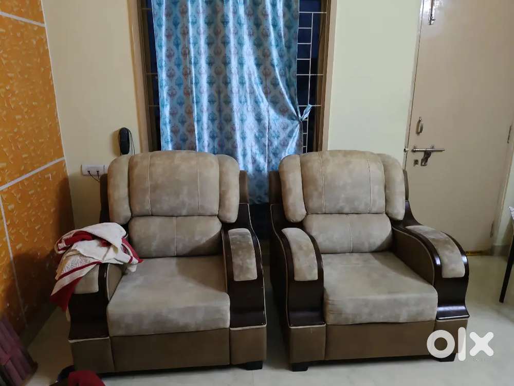 A beige colour sofa set which can accomodate upto 2 members.