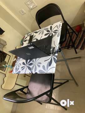 Black and white foldable table with 2 chairs.