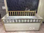 A solid wooden baby crib with additonal storage box