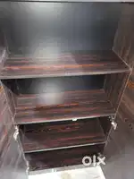 This is a two-door wooden wardrobe or almirah with internal shelving. 
