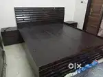 Double bed with side table and mattress.