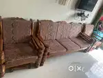 A high-quality Sheesham wood sofa with soft cushions.