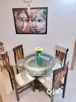 Round glass dining table with durable hard base paired with 4 chairs