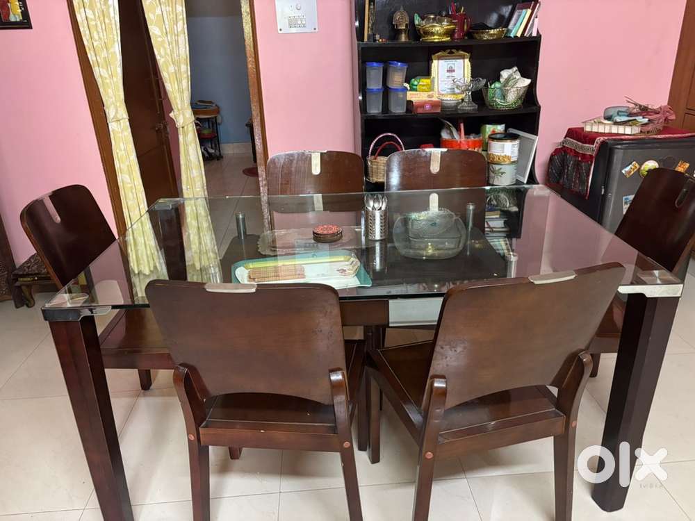 6 seater dining table with glass top a starage rack below with two