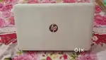 hp laptop of white colour with its charger included