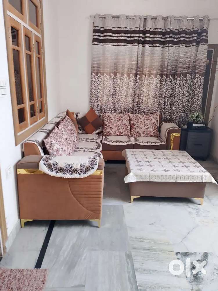 Ek six seater sofa set, aur ek square table and two stool.