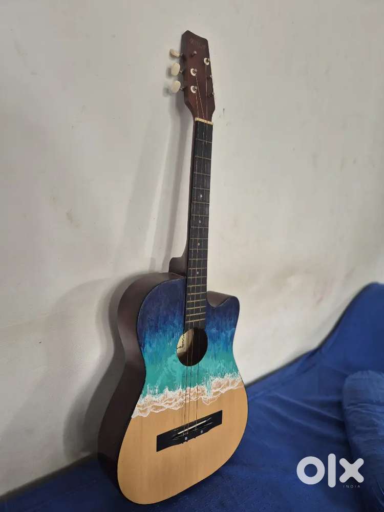 Acoustic guitar with a custom, hand-painted beach design.