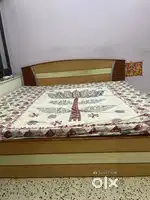 A wooden sofa cum double bed with mattress  with storage box