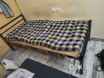 Single steel cot with wooden support and roll on mattress