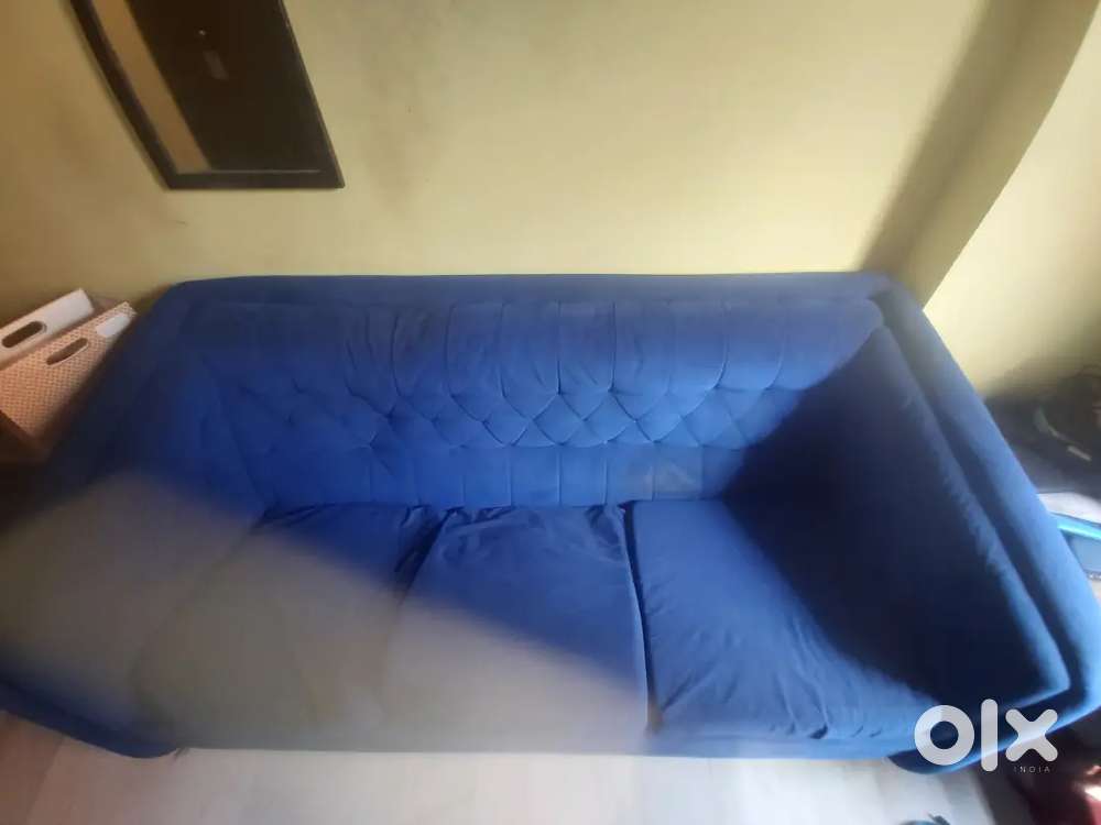 This is a three-seater sofa with a tufted backrest in a blue fabric.