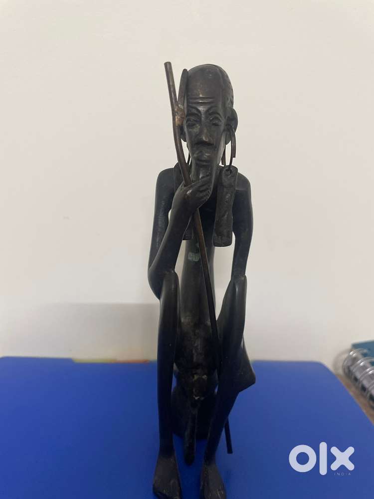 Original African statue of brass depicting an old man with stick .