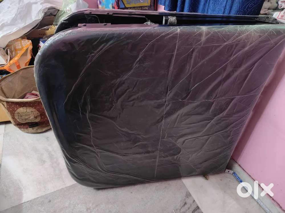 A folding single bed with mattress attached to it.