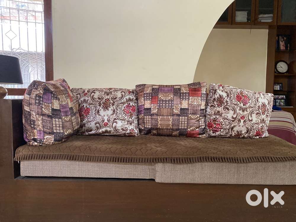 Socious L shaoed sofa cum bed with multiple velvet cusion covers