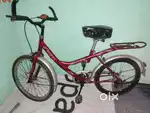 A red colour bicycle for girls and boys both