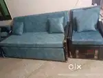 Sofa cum bed with two wooden chairs
