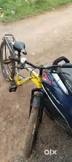 Cycle is yellow colour, other cycle is pink colour