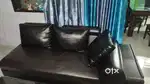 Leather couch L-shaped, 6 wide leather pillows. Dark brown in color