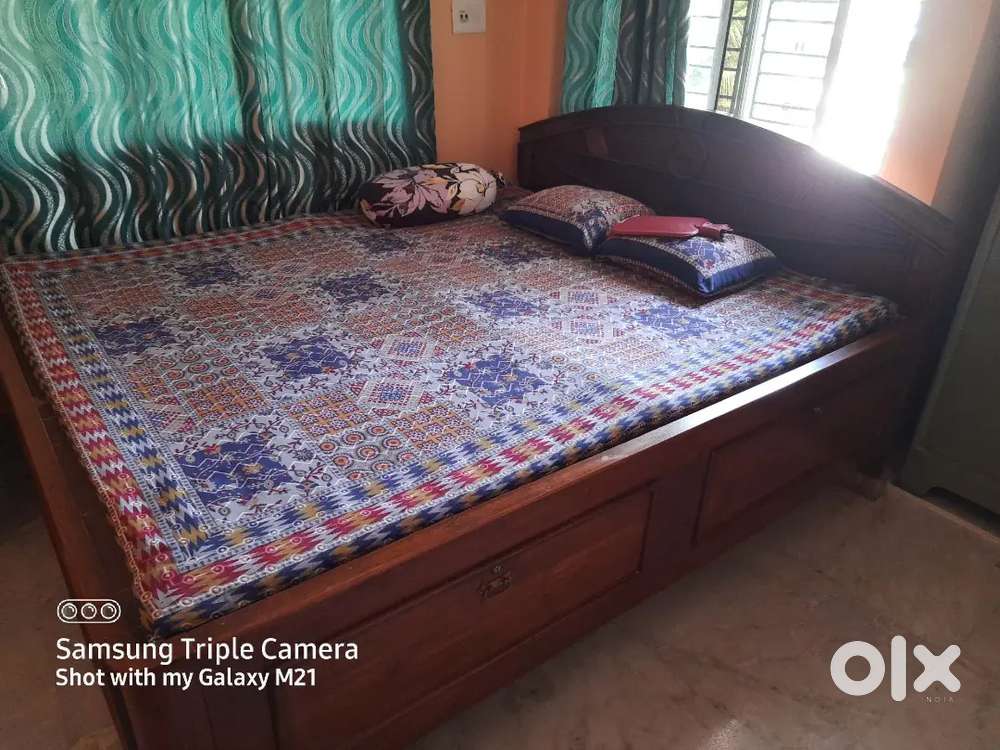 Teak wood King size bed with storage facility .