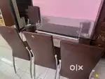 4 seaters Glass dining table with metal legs and 4 chairs for sale.