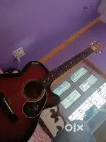 small size red guitar with a capo a bag