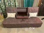 Sofa cum bed with foldable table in center.