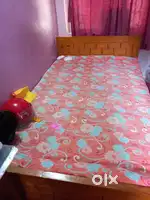 Wooden bed with mattress .