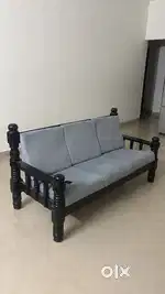 3 seater wooden sofa with cushions.