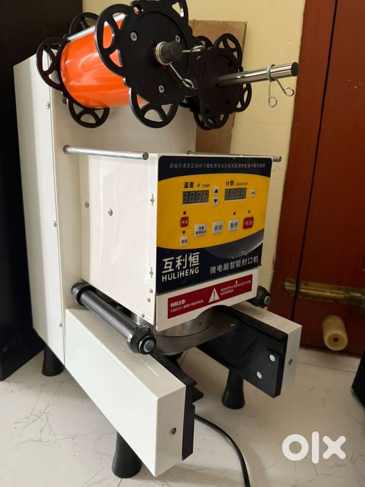 Juice cup sealing machine with seal rolls