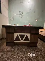 A wooden table with foot rest and a big and small drawer