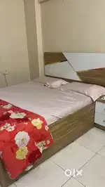 Queen size bed with mattress, side table.