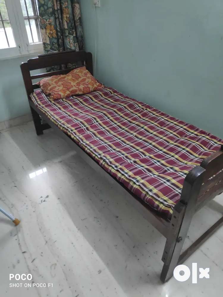 Single solid wood cot with matress and pillow .