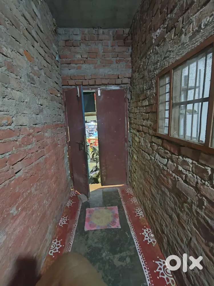 Single room with fan, bed, table, chair, almirah