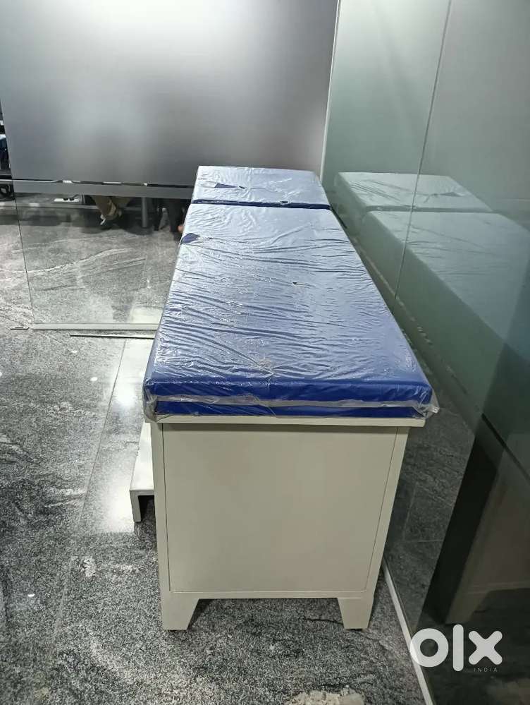 Hospital examination beds, fridge and computer table.
