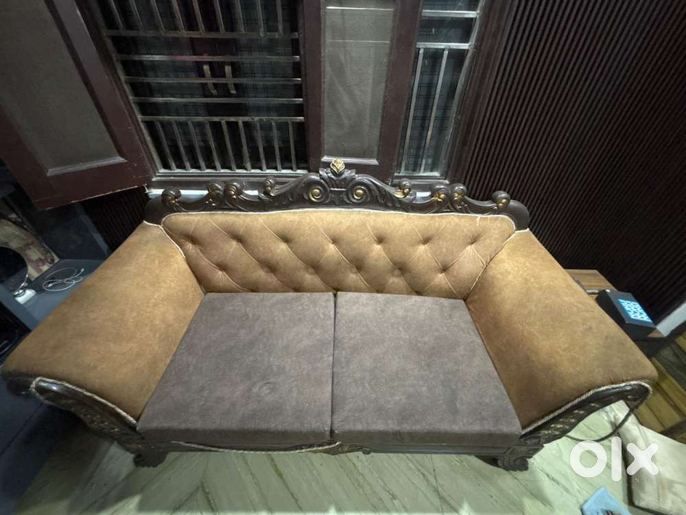 A wooden sofa with soft cushions which is durable,long lasting
