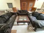 It is a 7seater sofa set with a center table, black in colour .