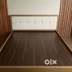 Brand new bed with a plush headboard and elegant wood panel design.