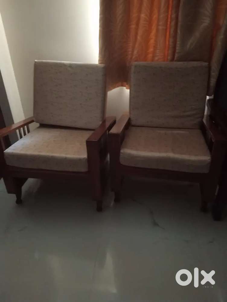 Two wooden single sofas.