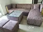 L shape sofa with glass center table and 2 puffy 4 cusions