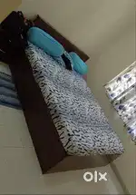 A queen size bed with mattress n mattress cover .