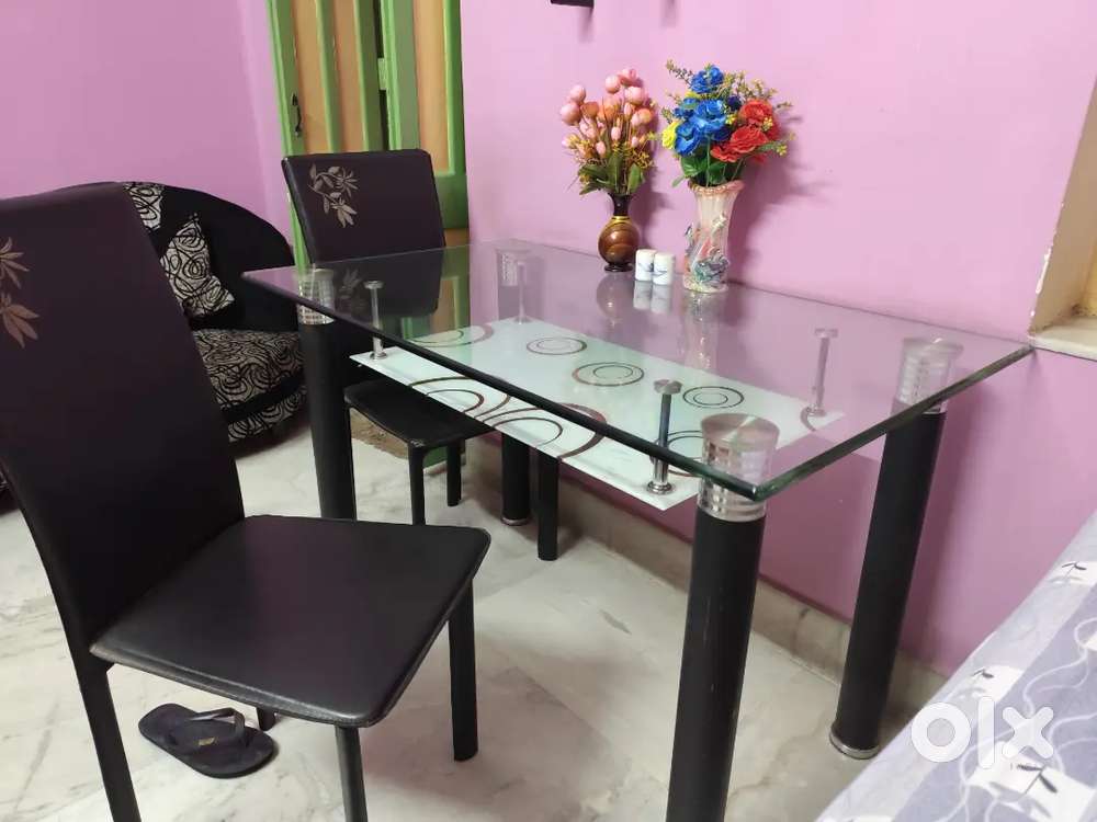 4 seater dining table, glass top with 4 designer chairs.